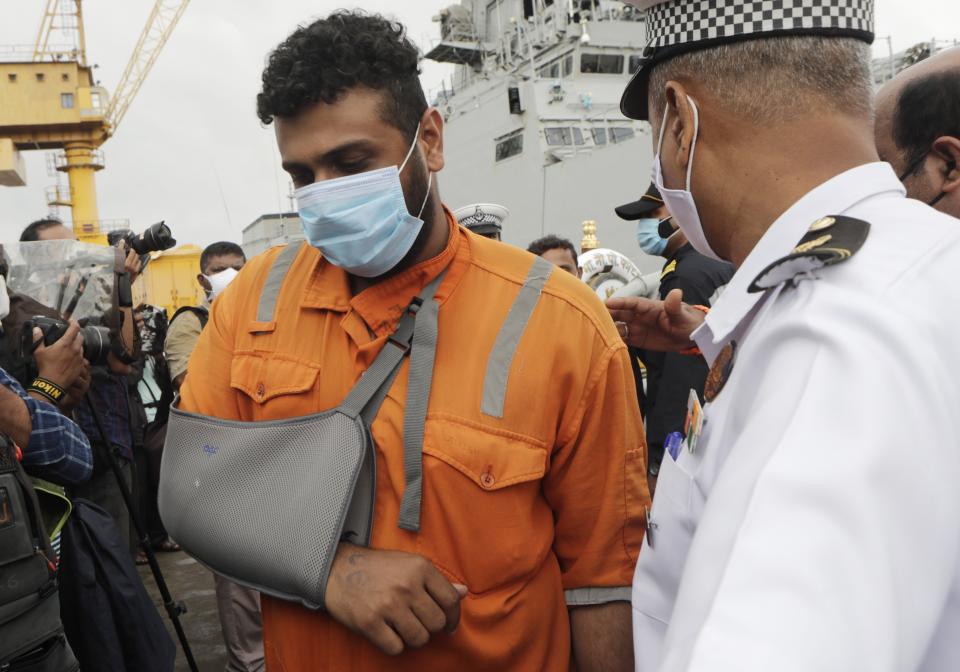 People rescued by the Indian navy from a barge that sank in the Arabian sea walk out from Indian naval ship INS Kochi in Mumbai, India, Wednesday, May 19, 2021. The barge carrying personnel deployed for offshore drilling sank off Mumbai as a deadly cyclone blew ashore this week. (AP Photo/Rajanish Kakade)