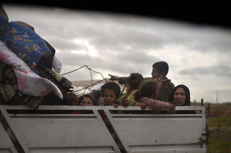 A Syrian family sits in the back of a truck as they leave the northern Syrian city of Aleppo on April 9, 2013