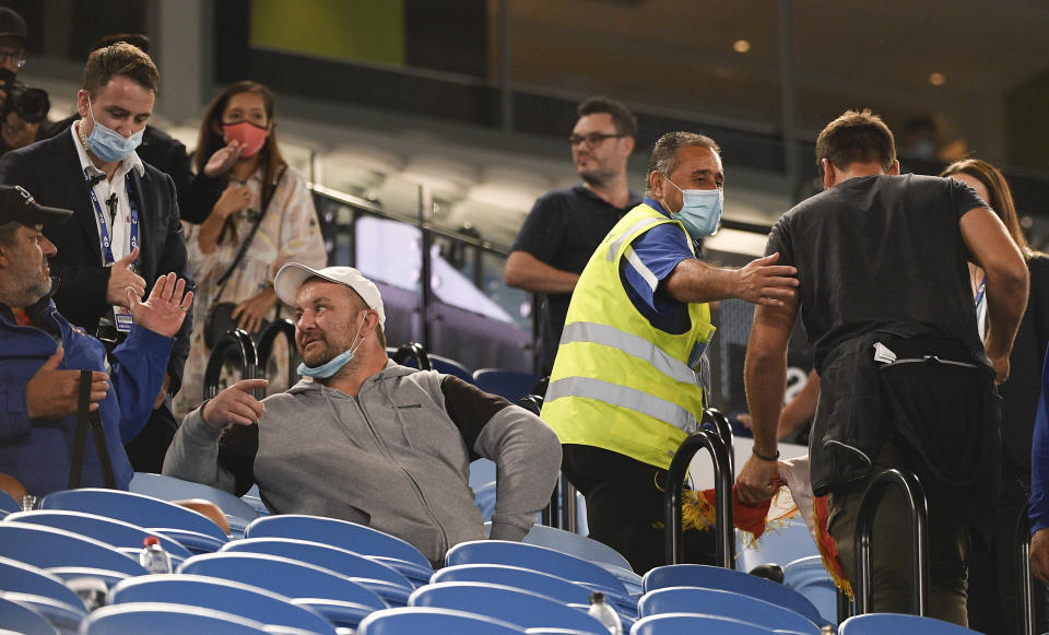 Security usher spectators from Rod Laver Arena during the third round match between Serbia's Novak Djokovic and United States' Talyor Fritz at the Australian Open tennis championship in Melbourne, Australia, Friday, Feb. 12, 2021. Melbourne, Australia's second-largest city, will begin its third lockdown on midnight Friday due to a rapidly spreading COVID-19 cluster centered on hotel quarantine.(AP Photo/Andy Brownbill)