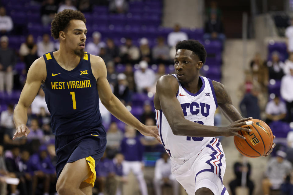 West Virginia's Emmitt Matthews Jr. (1) defends as TCU guard Damion Baugh (10) breaks to the basket in the first half of an NCAA college basketball game, Tuesday, Jan. 31, 2023, in Fort Worth, Texas. (AP Photo/Ron Jenkins)