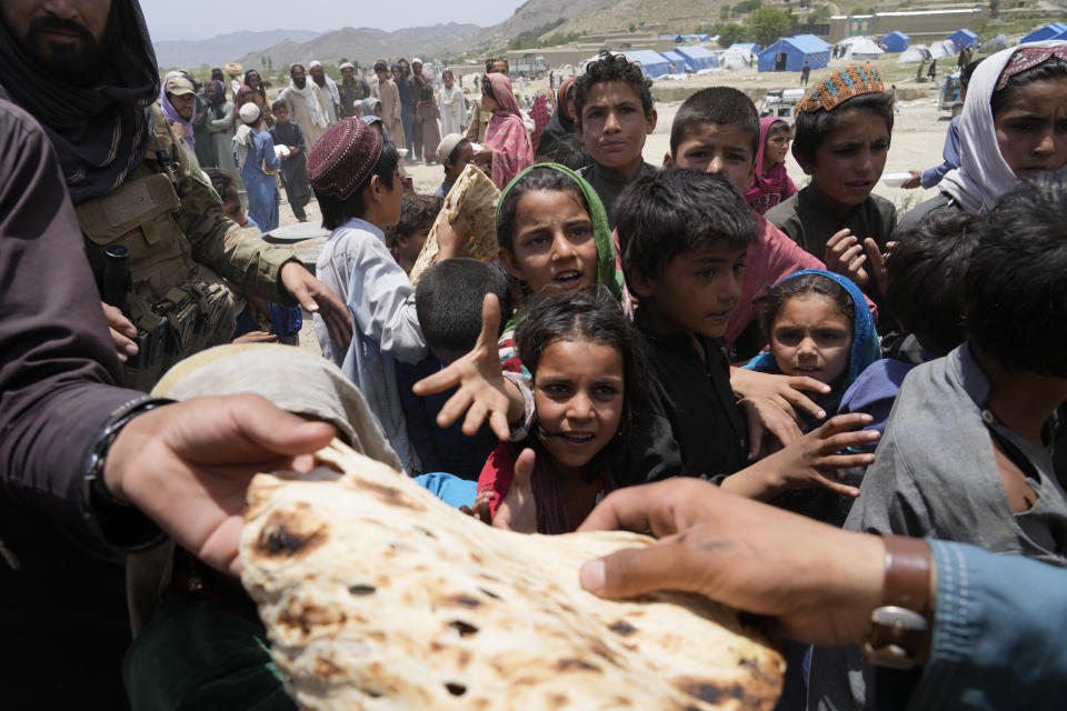 Afghans receive aid at a camp after an earthquake in Gayan district in Paktika province, Afghanistan, Sunday, June 26, 2022. A powerful earthquake struck a rugged, mountainous region of eastern Afghanistan early Wednesday, flattening stone and mud-brick homes in the country's deadliest quake in two decades, the state-run news agency reported. (AP Photo/Ebrahim Nooroozi)