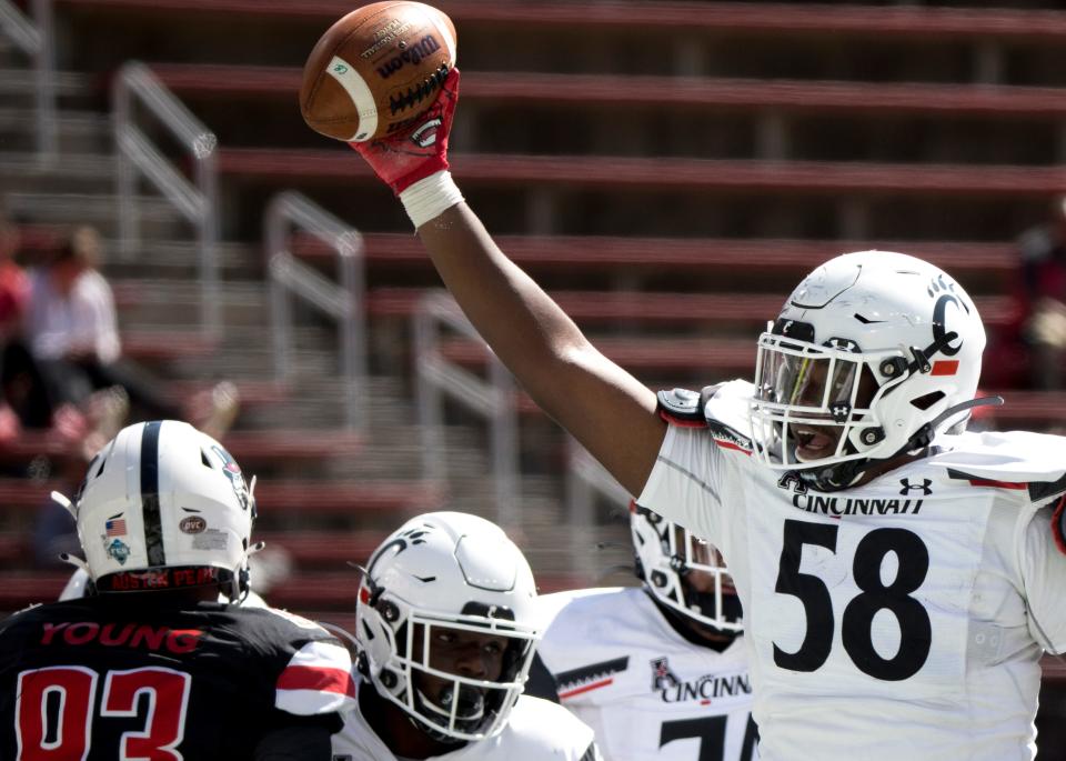 Cincinnati Bearcats offensive lineman Darius Harper (58) holds up the football while celebrating after Cincinnati Bearcats running back Jerome Ford (24) scored a touchdown on a two yard run in the third quarter of the NCAA football game between Cincinnati Bearcats and Austin Peay Governors on Saturday, Sept. 19, 2020, at Nippert Stadium in Cincinnati. Cincinnati Bearcats won 55-20. 