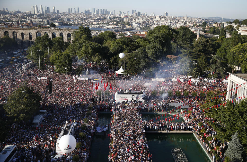 Thousands of supporters surround a bus from where Ekrem Imamoglu, the new Mayor of Istanbul from Turkey's main opposition opposition Republican People's Party (CHP) makes a speech after he took over office, in Istanbul, Thursday, June 27, 2019. Imamoglu is formally taking office as mayor of Istanbul four days after he won a repeat election in Turkey's largest city and commercial hub. (AP Photo/Lefteris Pitarakis)