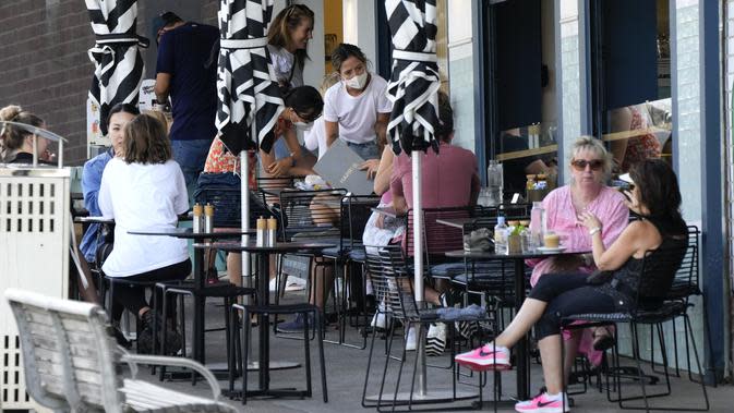 Pelanggan duduk di luar kafe di Pantai Bondi di Sydney, Australia, Sabtu (8/1/2022). Negara bagian terpadat di Australia itu telah memberlakukan kembali beberapa pembatasan dan menangguhkan operasi elektif ketika kasus COVID-19 melonjak ke rekor baru lainnya. (AP Photo/Mark Baker)