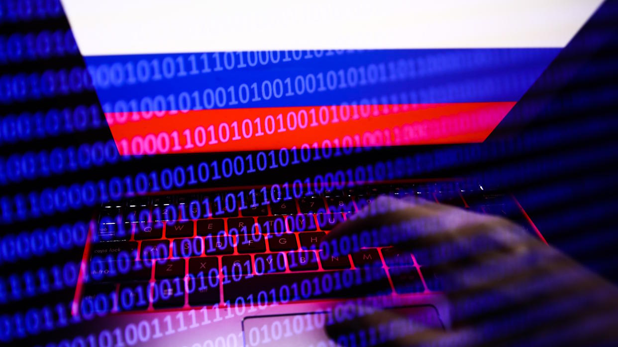 Russian flag displayed on a laptop screen and binary code code displayed on a screen are seen in this multiple exposure illustration photo taken in Krakow, Poland on February 16, 2022. (Photo illustration by Jakub Porzycki/NurPhoto via Getty Images). 