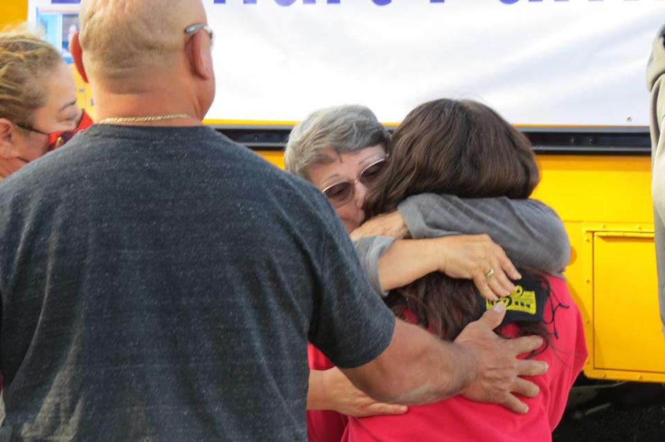 Nancy Lenhart was greeted with a hug when she got off of a school bus with her family in front of Longfellow Elementary School during a 2021 event honoring her late husband Richard “Dick” Lenhart.