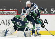 Vancouver Canucks center Bo Horvat (53) tries to clear Winnipeg Jets center Paul Stastny (25) from getting a shot against Canucks goaltender Braden Holtby (49) during second-period NHL hockey game action in Vancouver, British Columbia, Sunday, Feb. 21, 2021. (Jonathan Hayward/The Canadian Press via AP)