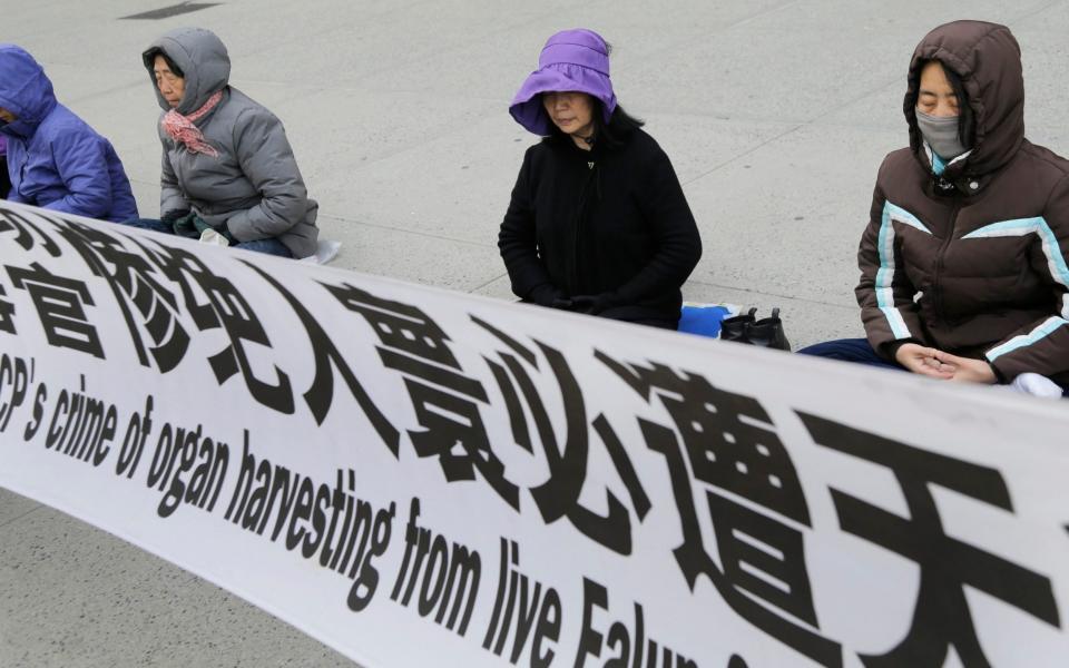 Practitioners of Falun Gong, meditate and exercise outside of the Chinese consulate, Thursday, April 25, 2019, in New York - Seth Wenig/AP Photo