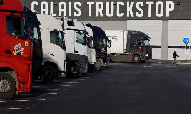 A lorrie driver walks past trucks at "Calais Truckstop" private parking in Marck