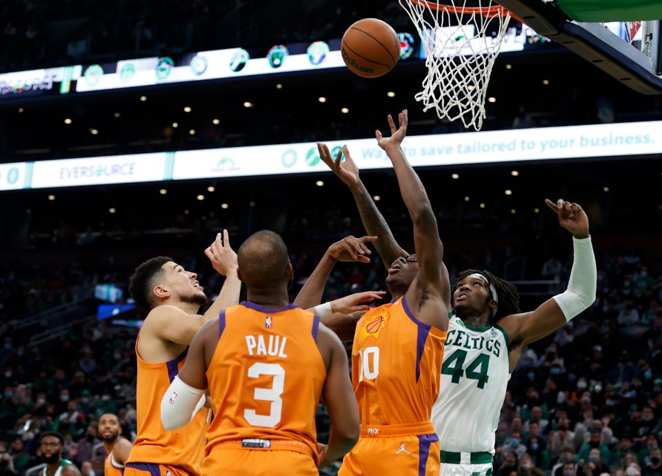 Boston Celtics center Robert Williams III (44) vies for a rebound with Phoenix Suns players Devin Booker, Chris Paul (3) and Jalen Smith (10) during the second half of an NBA basketball game, Friday, Dec. 31, 2021, in Boston. (AP Photo/Mary Schwalm)