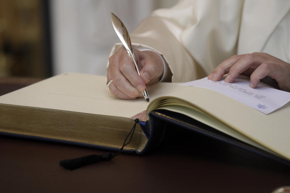 Pope Francis signs a guest book as he meets with Irish Prime Minister Leo Varadkar, in Dublin, Ireland, Saturday, Aug. 25, 2018. Pope Francis is on a two-day visit to Ireland. (AP Photo/Gregorio Borgia)