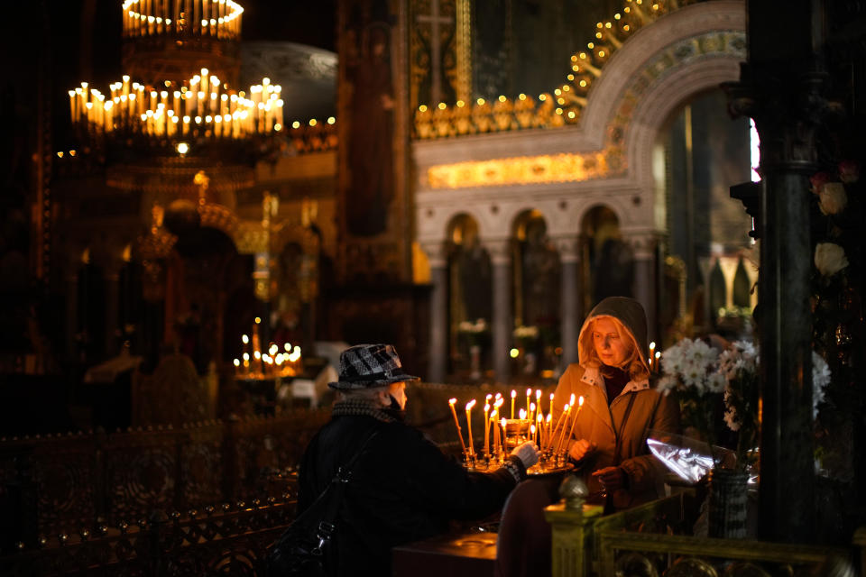 Worshippers light candles at the Saint Volodymyr's Cathedral during Orthodox Eastern celebrations in Kyiv, Ukraine, Sunday, April 24, 2022. The sun came out as Ukrainians marked Orthodox Easter in the capital, Kyiv, on Sunday with prayers for those fighting on the front lines and others trapped beyond them in places like Mariupol. (AP Photo/Francisco Seco)