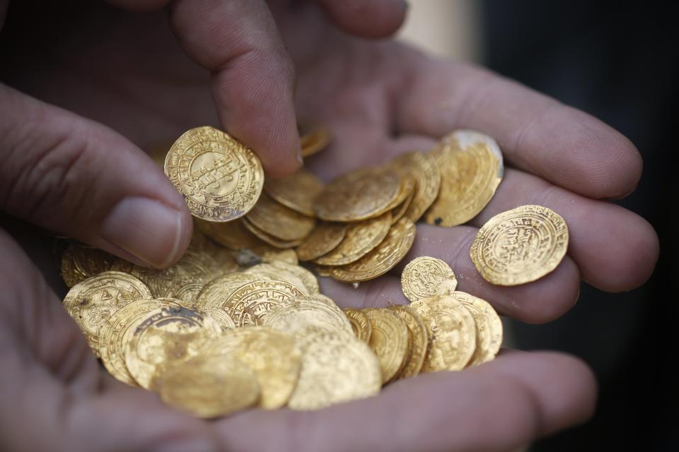 Ancient gold coins are displayed in Caesarea, north of Tel Aviv along the Mediterranean coast February 18, 2015. Almost 2,000 gold coins, believed to be from the 11th century, were found in recent weeks on the seabed by amateur divers who then alerted the Israel Antiquities Authority's Marine Archaeology Unit. REUTERS/Nir Elias (ISRAEL - Tags: MARITIME SOCIETY)