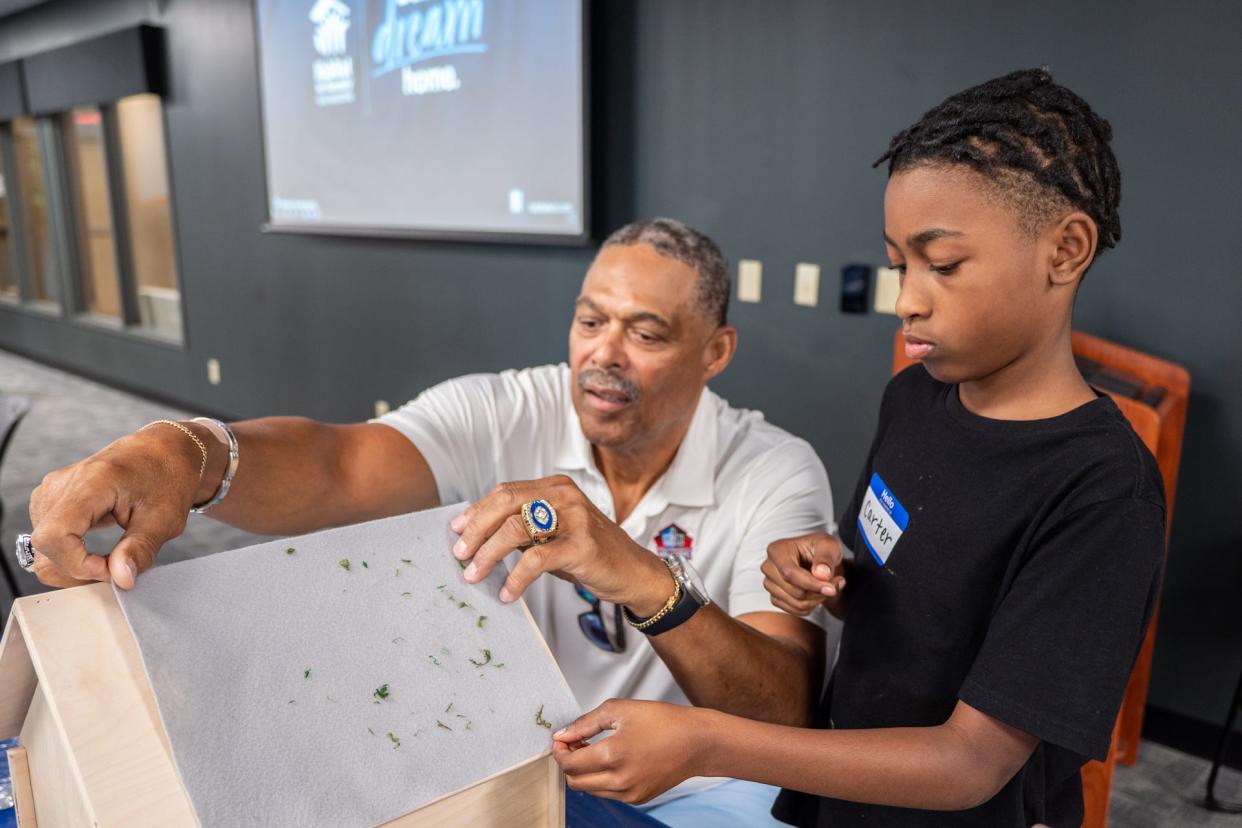 Pro Football Hall of Famer Robert Brazile helps Carter Pleasant of Canton with a "Dream Home" design project hosted by Habitat For Humanity East Central Ohio. Hall of Fame enshrinees and their wives and partners also helped with a wall raising at a new Habitat home in southeast Canton.