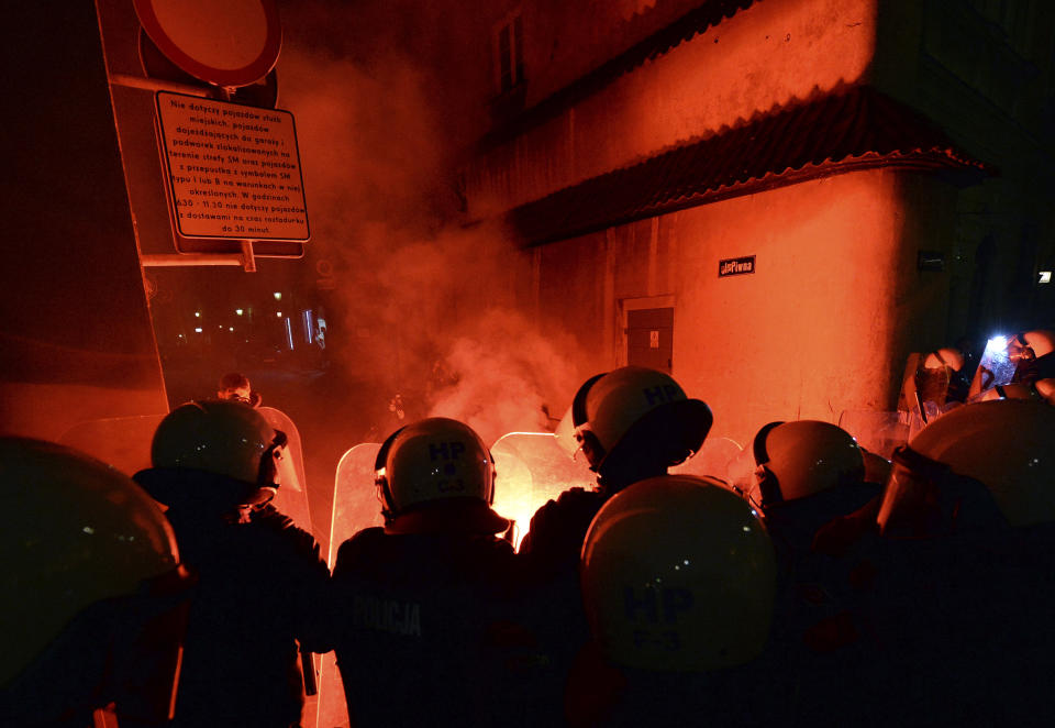 Police separate a far-right group from a protest against the conservative government on the eighth straight day of angry demonstrations that were triggered by a recent tightening of the abortion law, in the Old Town, in Warsaw, Poland, Friday, Oct. 30, 2020.(AP Photo/Czarek Sokolowski)