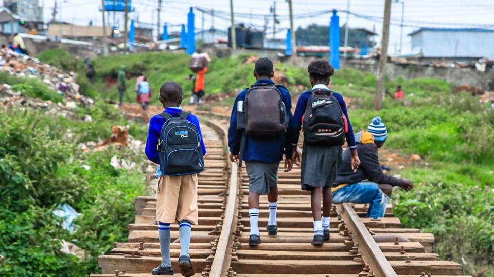 Children in school uniform walk along a train line in Nairobi, Kenya - Monday 13 May 2024