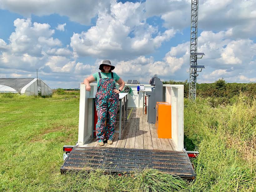 Cheyanne is pictured with the 27'x8' flatbed trailer. She turned it into a functional, portable washing and packing station for fruits and vegetables.