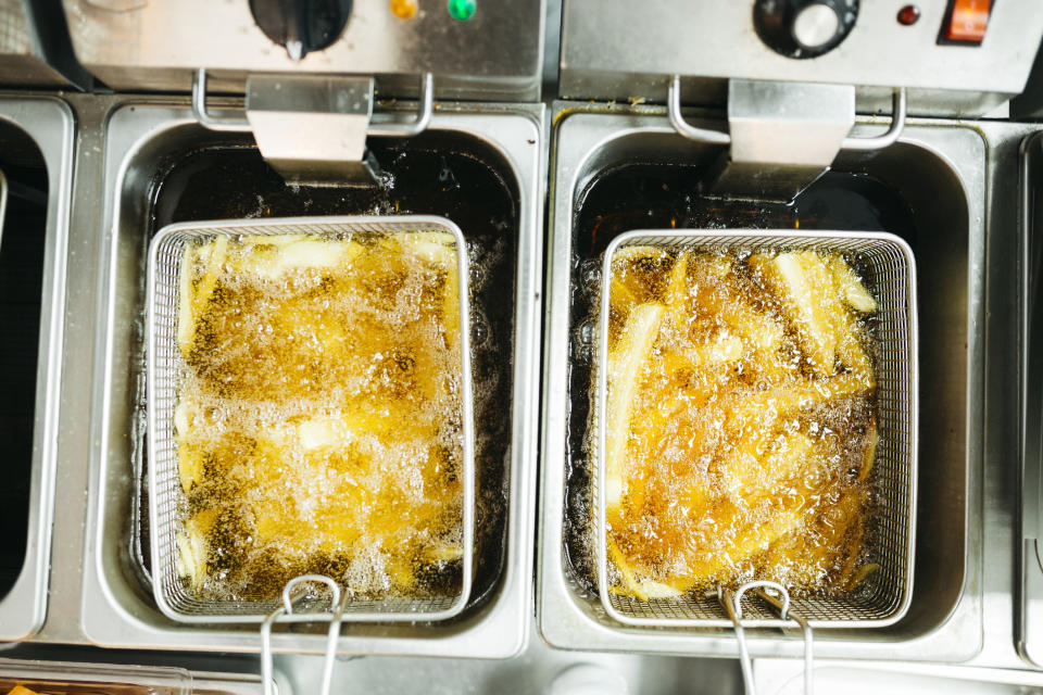 large baskets off fries in vats of oil