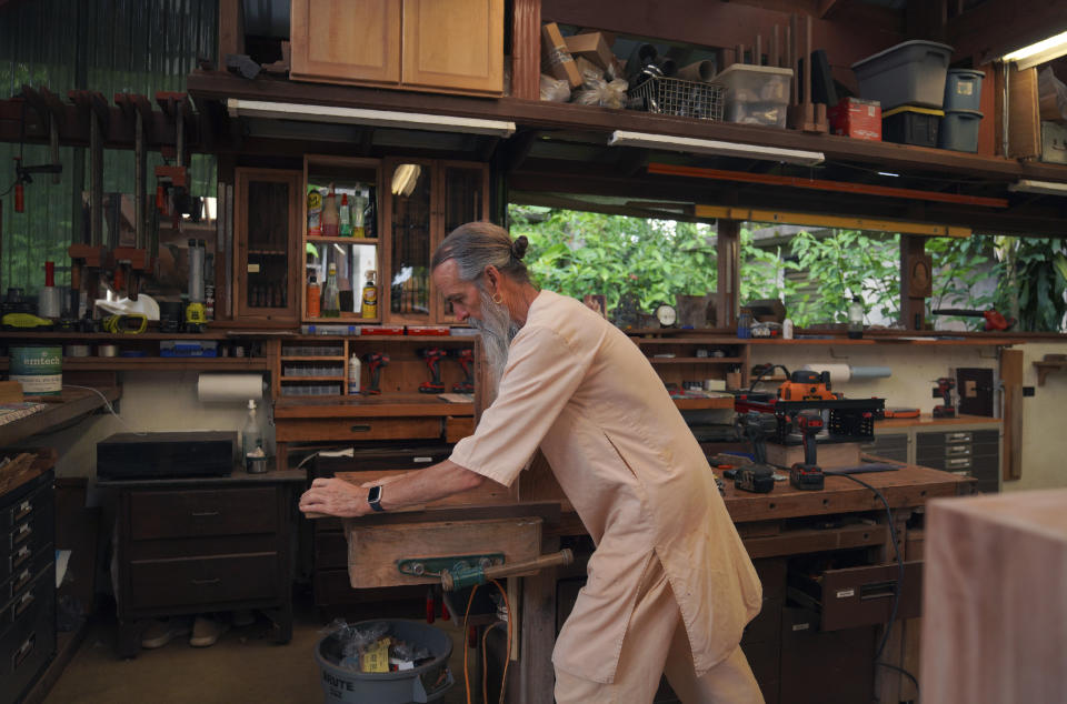 Acharya Kumarnathaswami shapes a piece of wood at Kauai's Hindu Monastery on July 10, 2023, in Kapaa, Hawaii. The monks who reside at the temple monastery practice Shaivism, one of the major Hindu traditions, which worships Shiva as the supreme being. (AP Photo/Jessie Wardarski)