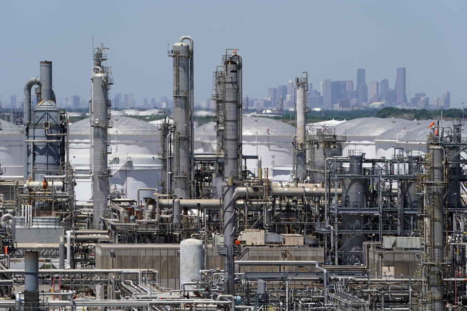 In this Thursday, April 30, 2020, photo a refinery along the Houston Ship Channel is seen with downtown Houston in the background. Like in other cities, the coronavirus has shut down much of Houston's economic activity, slashing thousands of jobs, while at the same time, the price of oil plunged below zero recently as demand plummeted due to the worldwide lockdown to stop the spread of the virus. This one-two punch from COVID-19 and the collapse in oil prices will make it much harder for Houston to recover from a looming recession, according to economists. (AP Photo/David J. Phillip)