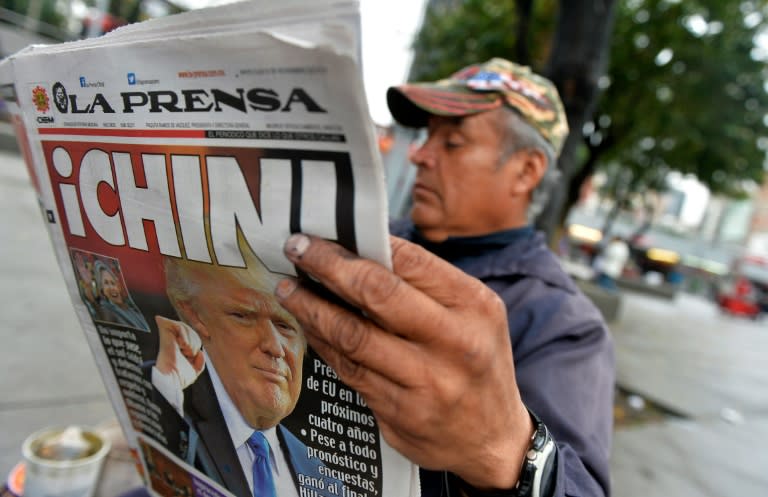 A Mexican reads a newspaper with headlines about Donald Trump on November 9, 2016 in Mexico City