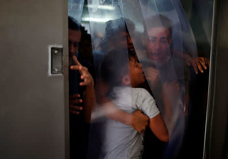 Relatives of a Palestinian, who was killed at the Israel-Gaza border, react at a hospital in Gaza City June 18, 2018. REUTERS/Mohammed Salem