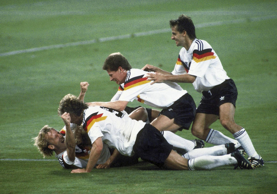 FILE - Germany players celebrate after Andreas Brehme, left on ground, scores the winning goal in the World Cup soccer final match against Argentina, in the Olympic Stadium, in Rome, July 8, 1990. Andreas Brehme, who scored the only goal as West Germany beat Argentina to win the 1990 World Cup final, has died. He was 63. Brehme’s partner Susanne Schaefer has confirmed his death in a statement to Germany’s dpa news agency. (AP Photo/Carlo Fumagalli, File)