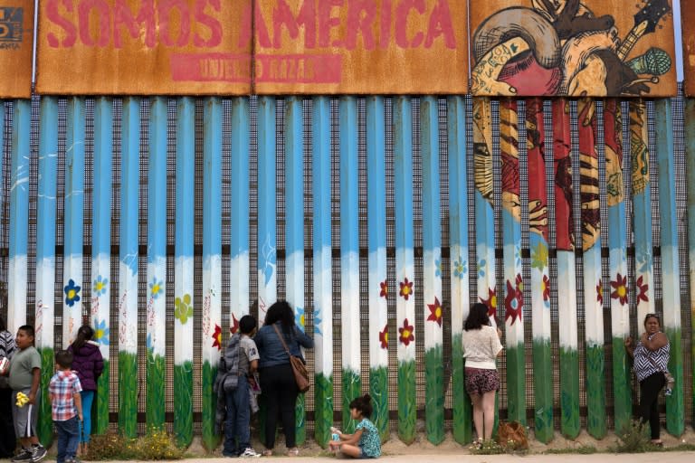 People gather at the US-Mexico border fence to talk to their relatives in Playas de Tijuana, northwestern Mexico