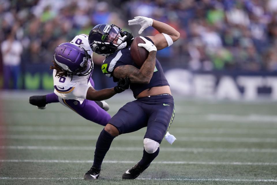 Seattle Seahawks wide receiver Jaxon Smith-Njigba (11) is tackled by Minnesota Vikings safety Lewis Cine (6) during an NFL pre-season football game against the Minnesota Vikings, Thursday, Aug. 10, 2023 in Seattle. (AP Photo/Ben VanHouten)