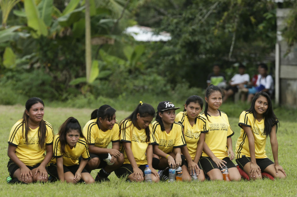 In this Nov. 25, 2018 photo, a group of Guna women sit on the field during a penalty shootout in the women's soccer competition of the second edition of the Panamanian indigenous games in Piriati, Panama. The Guna women won the match and advanced to the semifinal and won the championship. (AP Photo/Arnulfo Franco)