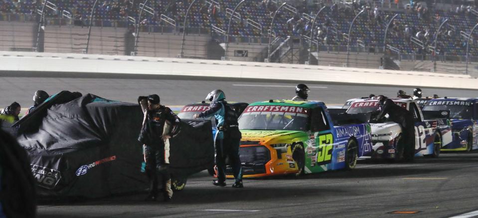 Crews cover their trucks as a light rain falls on the Daytona International Speedway, Friday night February 17, 2023 bring out several red flags during the NextEneergy 250.