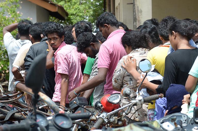 Sri Lankan asylum seekers sent back by Australia queue to enter the magistrate's court in the southern port district of Galle on July 8, 2014