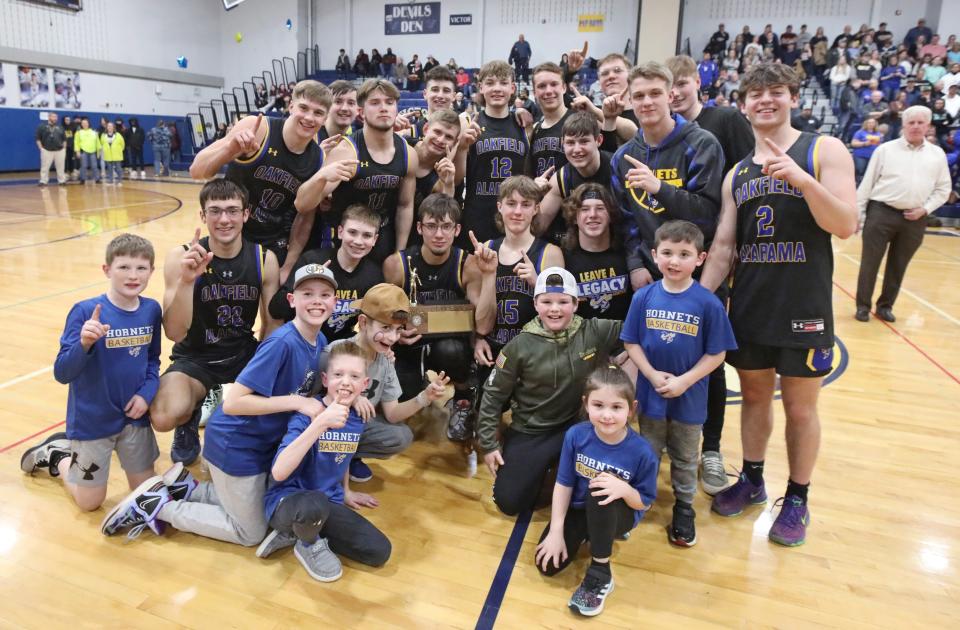 Oakfield-Alabama celebrate with the Class C2 championship trophy after their victory over Lyons, 55-29, in their Section V Class C2 championship final Friday, March 4, 2022 at Victor High School. 