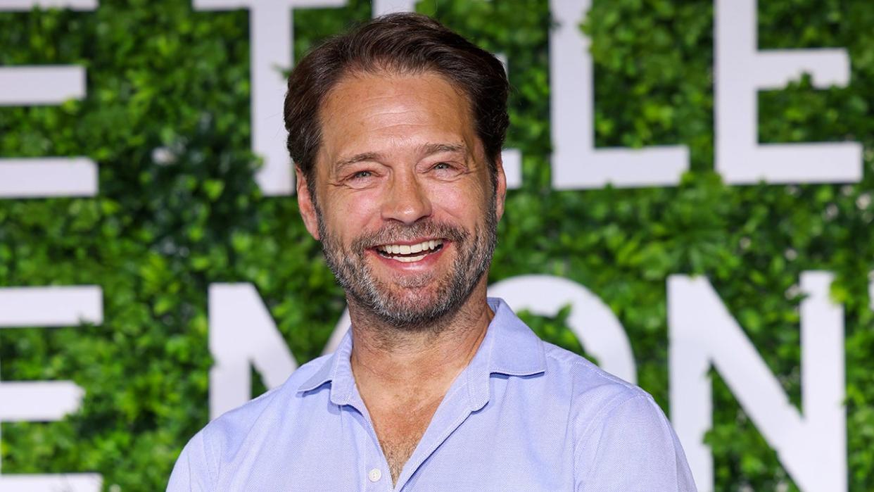 Jason Priestly wears a blue shirt at an event