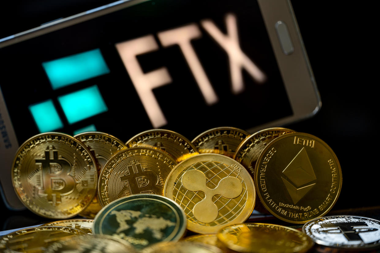 FTX logo with crypto coins with 100 Dollar bill are displayed for illustration. FTX has filed for bankruptcy in the US, seeking court protection as it looks for a way to return money to users.  (Photo illustration by Jonathan Raa/NurPhoto via Getty Images)