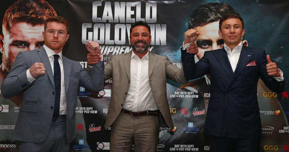 Canelo Alvarez and Gennady Golovkin pose for a picture with Oscar de la Hoya.