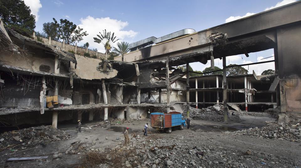 Workers continue the long process of removing rubble from the damaged Westgate Mall in Nairobi, Kenya Tuesday, Jan. 21, 2014. Court officials and four handcuffed ethnic Somalis accused of aiding the gunmen who attacked Nairobi's Westgate Mall in Sept. 2013, walked through the heavily damaged shopping center on Tuesday led by Chief Magistrate Daniel Ochenja, to help the court visualize the mall's layout for the ongoing trial of the four men. (AP Photo/Ben Curtis)