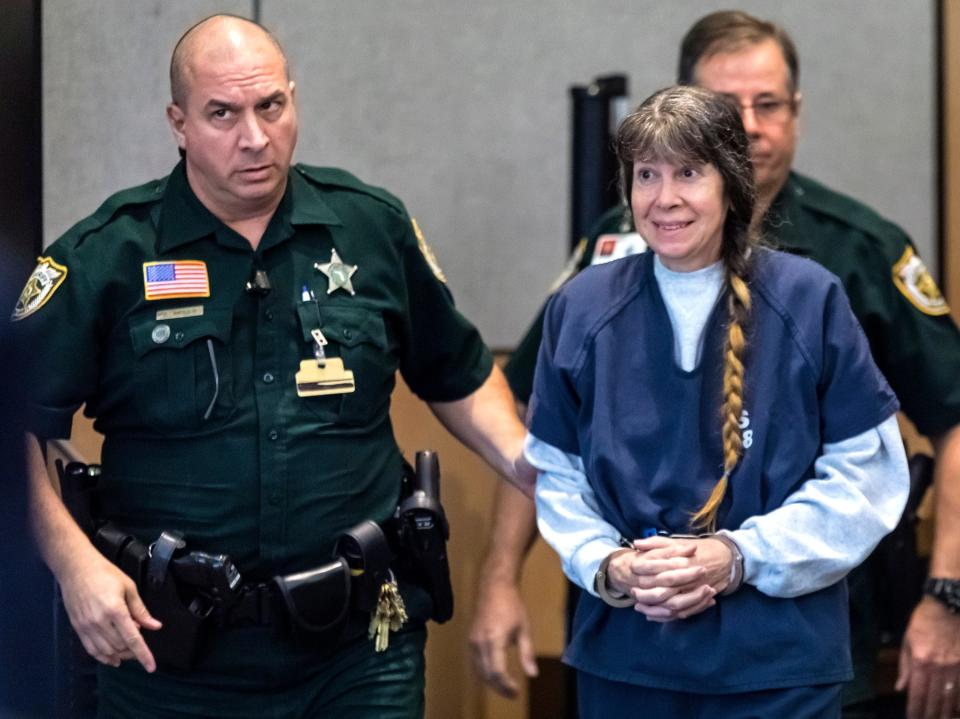 Sheila Keen-Warren smiles at her defense attorneys as she is brought into court Friday, November 22, 2019 for a pretrial hearing in her first-degree murder case.  Keen-Warren is accused of dressing as a clown and fatally shooting her lover?s wife, Marlene Warren, in Wellington in 1990.