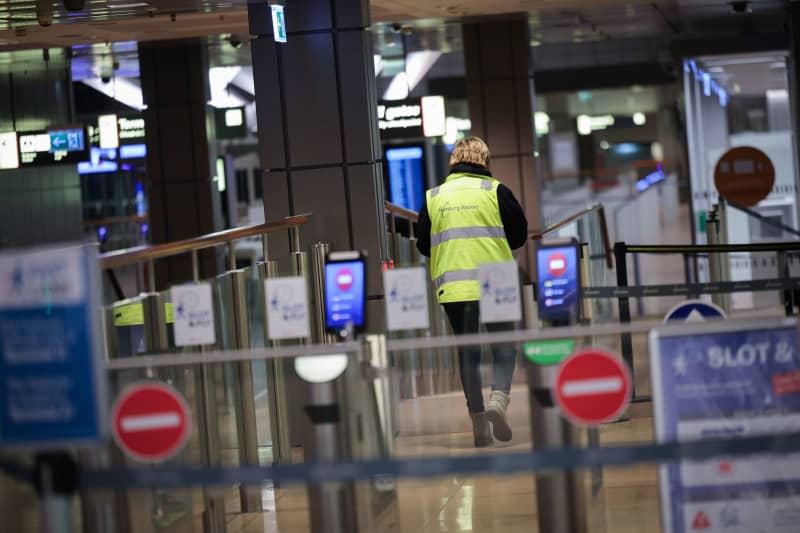 An airport employee walks through the closed and deserted security checkpoint at Hamburg Airport, one of 11 major German airports that have started a one-day strike. Christian Charisius/dpa
