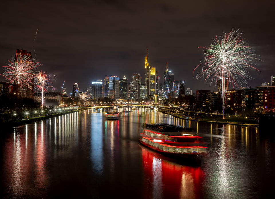 Party boats cruise over the river Main with only a few fireworks near the buildings of the banking district in Frankfurt, Germany, early Saturday, Jan. 1, 2022. Due to the coronavirus pandemic fireworks were not allowed. (Photo/Michael Probst)