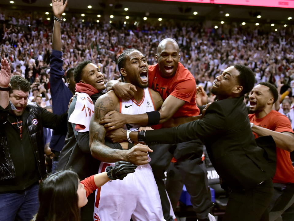 El alero de los Raptors de Toronto Kawhi Leonard, centro, celebra su tiro ganador al término del partido de la NBA contra los 76ers de Filadelfia, el domingo 12 de mayo de 2019, en Toronto. (Frank Gunn/The Canadian Press via AP)