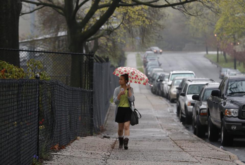 A girl walks to school near Teaneck High School, where at least 60 students were arrested during an overnight break-in, Thursday, May 1, 2014, in Teaneck, N.J. Officers responded to a burglar alarm at the school around 2:30 a.m. Thursday, found urine in the hallways, petroleum jelly on doorknobs, desks flipped over and balloons throughout the building. (AP Photo/Julio Cortez)