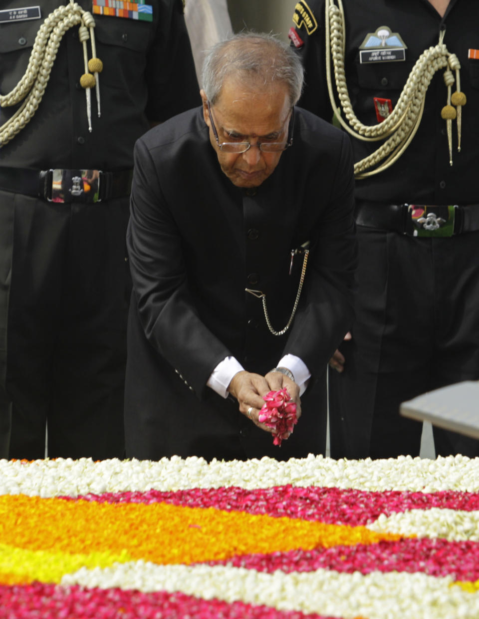 Political veteran Pranab Mukherjee offers flower petals at Rajghat, the memorial to the late Mahatma Gandhi, in New Delhi, India, Wednesday, July 25, 2012. Mukherjee was sworn in Wednesday as India's 13th president in an elaborate and symbolic ceremony in Parliament. (AP Photo/Altaf Qadri)