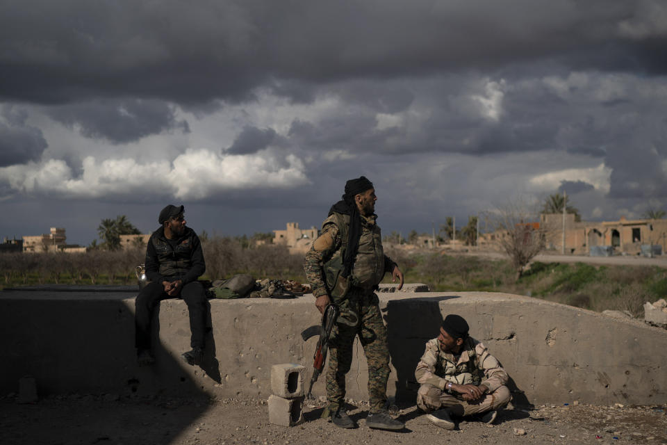 U.S.-backed Syrian Democratic Forces (SDF) fighters stand in an area recently taken by SDF as fight against Islamic State militants continue in the village of Baghouz, Syria, Sunday, Feb. 17, 2019. Islamic State militants are preventing more than 1,000 civilians from leaving a tiny area still held by the extremist group in a village in eastern Syria, a spokesman for the U.S.-backed Syrian militia fighting the group said Sunday. (AP Photo/Felipe Dana)