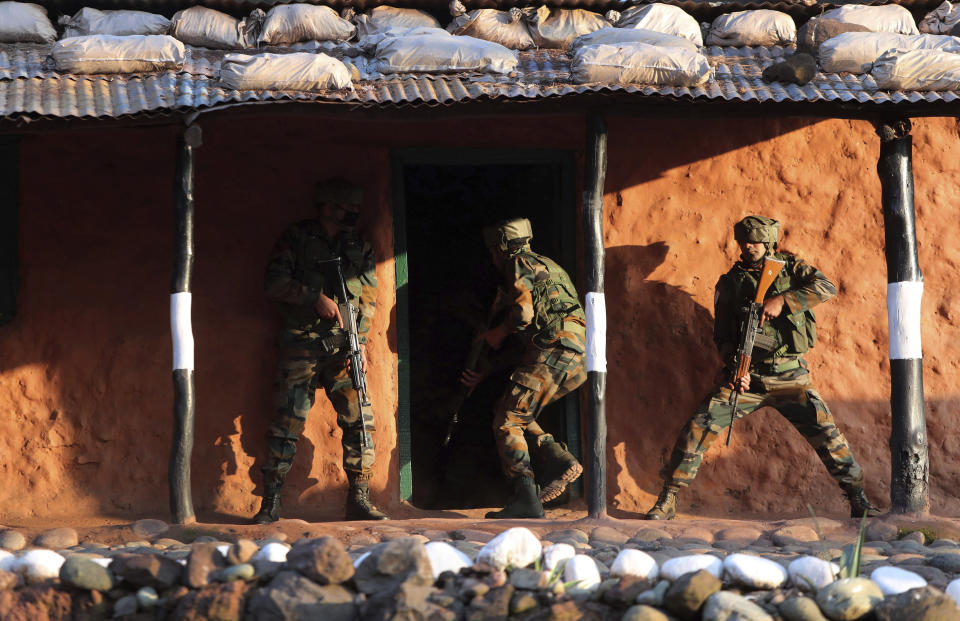 Indian army soldiers display a cordon and search operation (CASO) during a training session at a corps battle school at Sarol in Rajouri, about 135 kilometers (84 miles) northwest of Jammu, India, Tuesday, Dec. 15, 2020. AP journalists were recently allowed to cover Indian army counterinsurgency drills in Poonch and Rajouri districts along the Line of Control. The training focused on tactical exercises, battle drills, firing practice, counterinsurgency operations and acclimatization of soldiers to the harsh weather conditions. (AP Photo/Channi Anand)