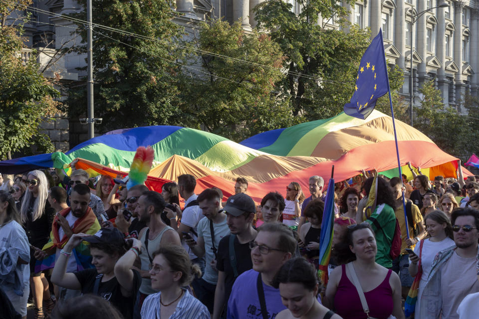 People carry a rainbow flag as they attend a pride march in Belgrade, Serbia, Saturday, Sept. 7, 2024. (AP Photo/Marko Drobnjakovic)