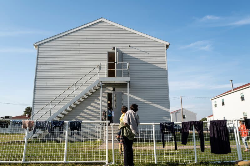 Afghan refugees stand outside housing in the Village, where they are temporarily living at Fort McCoy U.S. Army base