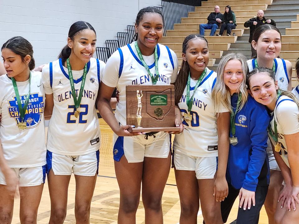 Olentangy's Sydney Mobley, center, flanked by teammates Chayla Ranking (22) and Alex Mobley (20), holds the Division I district championship trophy Saturday at Ohio Dominican. The Braves defeated Upper Arlington 57-40 for their first district title since 1998.