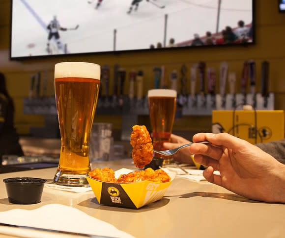 A customer enjoys wings and a beer at Buffalo Wild Wings.