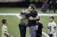 New Orleans Saints quarterback Drew Brees right, embraces Tampa Bay Buccaneers quarterback Tom Brady as Bree's children look on after an NFL divisional round playoff football game between the New Orleans Saints and the Tampa Bay Buccaneers, Sunday, Jan. 17, 2021, in New Orleans. The Tampa Bay Buccaneers won 30-20. (AP Photo/Butch Dill)